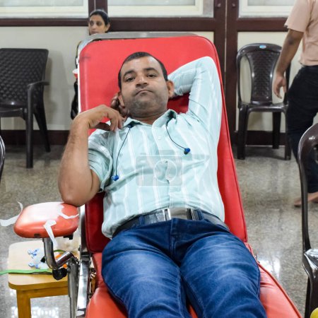 Foto de Delhi, India, 19 de junio de 2023 - Donante de sangre en el campamento de donación de sangre celebrado en el Templo Balaji, Vivek Vihar, Delhi, India, Imagen para el Día Mundial del Donante de Sangre el 14 de junio de cada año, Campamento de Donación de Sangre en el Templo - Imagen libre de derechos