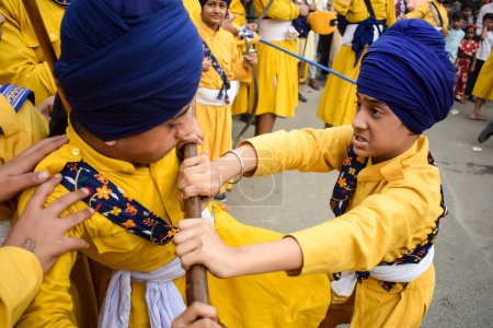 Foto de Delhi, India, 2 de octubre de 2023 - Los sikhs exhiben gatka y artes marciales durante la procesión anual de Nagar Kirtan, tradicional, debido al cumpleaños del Guru Nanak Dev ji, Nagar Kirtan en el área de East Delhi - Imagen libre de derechos