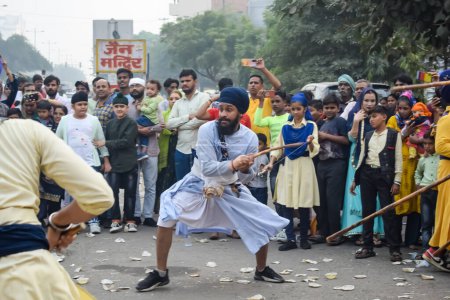 Photo for Delhi, India, October 2, 2023 - Sikhs display gatka and martial arts during annual Nagar Kirtan, Traditional, procession on account of birthday of Guru Nanak Dev ji, Nagar Kirtan in East Delhi area - Royalty Free Image