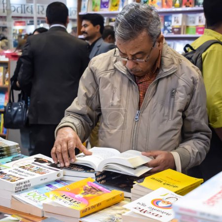 Photo for Delhi, India, February 17 2024 - Various age group people reading variety of Books on shelf inside a book-stall at Delhi International Book Fair, Books in Annual Book Fair at Bharat Mandapam complex - Royalty Free Image