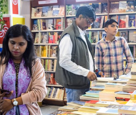 Photo for Delhi, India, February 17 2024 - Various age group people reading variety of Books on shelf inside a book-stall at Delhi International Book Fair, Books in Annual Book Fair at Bharat Mandapam complex - Royalty Free Image