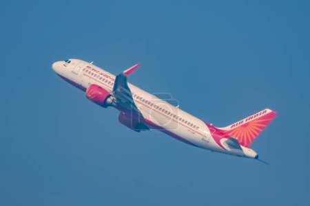 Téléchargez les photos : New Delhi (Inde), le 25 décembre 2023 - L'Airbus A320 d'Air India décolle de l'aéroport international Indra Gandhi Delhi (Inde), avion intérieur d'Air India volant dans le ciel bleu pendant la journée - en image libre de droit