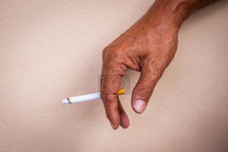 Foto de Primer plano de la mano de un hombre trabajando duro fumando un cigarrillo con humo. Textura de fondo - Imagen libre de derechos