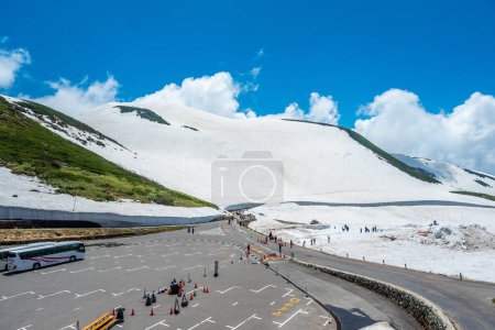 Photo for Parking spot for tourists snow mountains wall of Tateyama Kurobe alpine with blue sky background is one of the most important and popular natural place in Toyama Japan. - Royalty Free Image