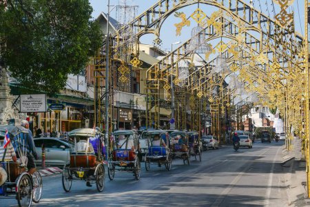 Foto de CHIANGMAI, TAILANDIA - 24 de diciembre: Triciclo taxi en la calle Tha Phae para los clientes que visitan Chiang Mai, Tailandia.Triciclo taxi en bicicleta es uno de los transportes públicos en Tailandia. - Imagen libre de derechos