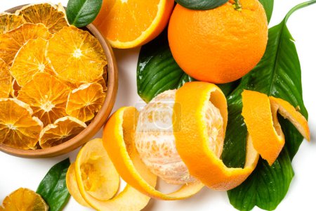 Téléchargez les photos : Tranches d'orange sèches et fruits frais sur fond blanc. Snacks déshydratés de fruits orange. Sain, pas de sucre sucré. Agrumes confits - en image libre de droit