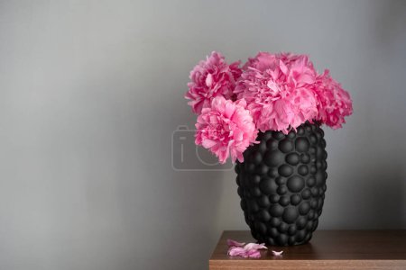 Téléchargez les photos : La pivoine ou paeony fleurs roses dans un vase sur l'étagère. Bouquet Paeonia "Sarah Bernhardt" sur fond gris. Accueil concept intérieur - en image libre de droit