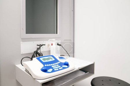 Foto de Audiómetro digital con auriculares en una cabina de pruebas insonorizadas, configurado para realizar evaluaciones auditivas precisas en una clínica médica - Imagen libre de derechos