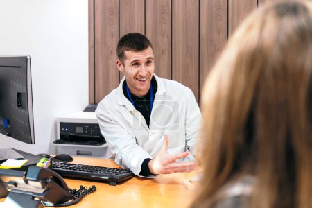 Foto de Médico en animada charla con el paciente sobre problemas de salud. - Imagen libre de derechos