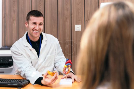 Cheerful doctor discusses cardiology with patient.