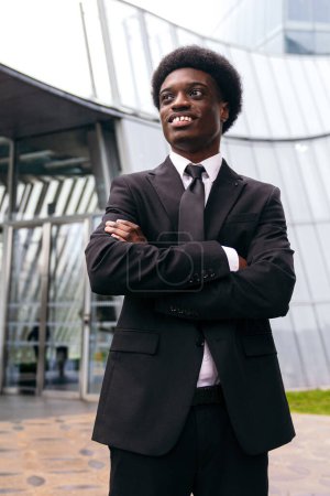 Photo for Pensive african young entrepreneur outside a modern facade. - Royalty Free Image