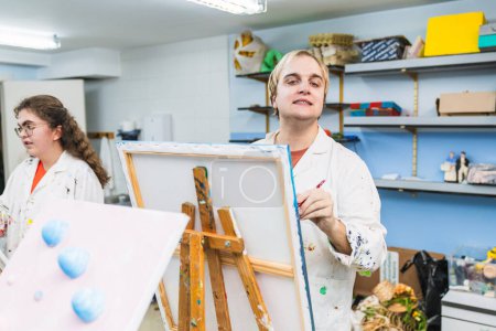 Foto de Artista motivado con discapacidad que trabaja en una pintura en una clase alegre - Imagen libre de derechos