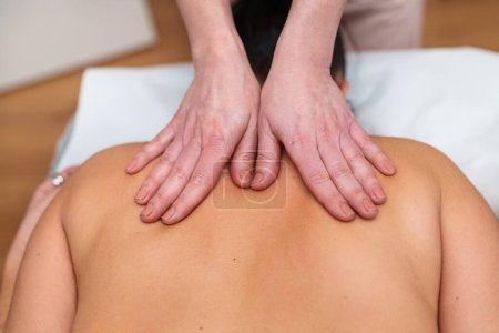Photo for Focused hands massage a patient's back, promoting relaxation and wellness. - Royalty Free Image