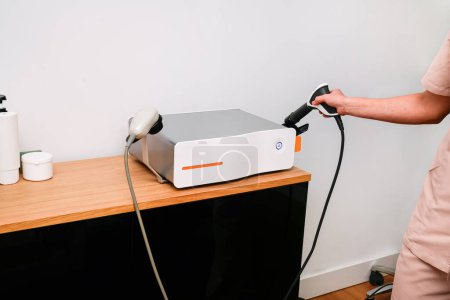 Una máquina de terapia de ondas de choque instalada en una clínica para el tratamiento de tejidos profundos en rehabilitación.
