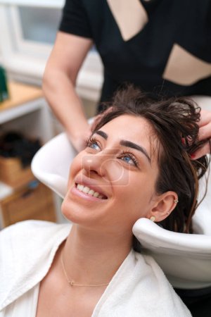 Photo for Client smiles during a preparatory hair wash at a stem cell clinic. - Royalty Free Image