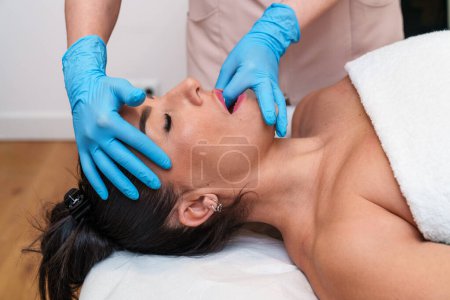 Téléchargez les photos : Le patient reçoit un traitement d'étirement TMJ pour soulager l'inconfort de la mâchoire. - en image libre de droit