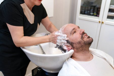 Photo for Client enjoys a relaxing shampoo at hair treatment salon - Royalty Free Image