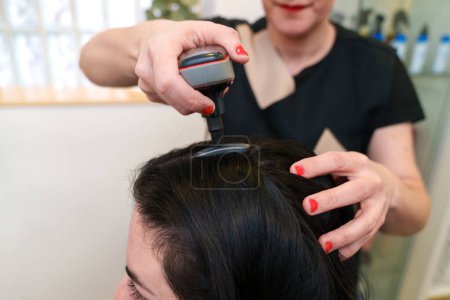 Photo for Technician performs hair strengthening treatment. - Royalty Free Image