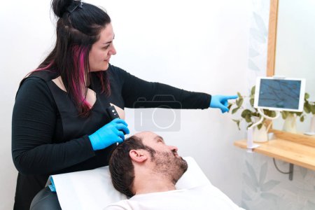 Photo for Healthcare professional provides a scalp examination for a client. - Royalty Free Image