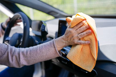 Photo for A detailed shot of a hand cleaning a steering wheel, ensuring hygiene and care. - Royalty Free Image