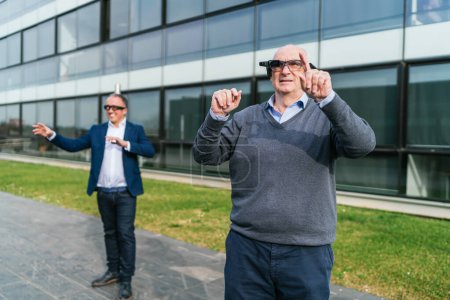Empresarios explorando la realidad virtual en el exterior, usando gafas VR e interactuando con interfaces digitales con entusiasmo.