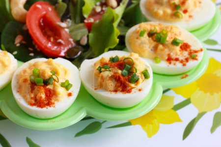 Deviled eggs - Ostereier gefüllt. Frühlingsvorspeise - klassische teuflische Eier mit frischem Gemüsesalat