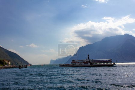 Foto de Torbole - Nago, Lago de Garda, Barco de vapor vintage en el lago de Garda, cerca de la ciudad de Torbole Nago. Buque de vapor italiano con pasajeros en el puerto, Trentino, Italia - Imagen libre de derechos