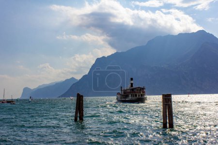Foto de Torbole - Nago, Lago de Garda, Barco de vapor vintage en el lago de Garda, cerca de la ciudad de Torbole Nago. Buque de vapor italiano con pasajeros en el puerto, Trentino, Italia - Imagen libre de derechos