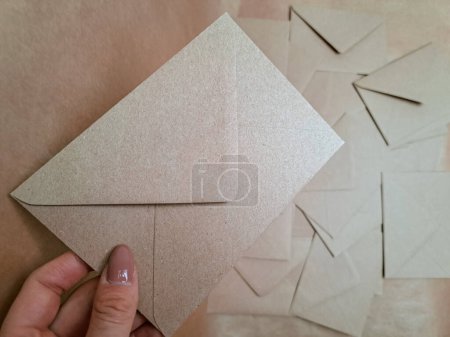 Téléchargez les photos : Enveloppes en papier artisanal dans les mains espace de copie arrière-plan , - en image libre de droit