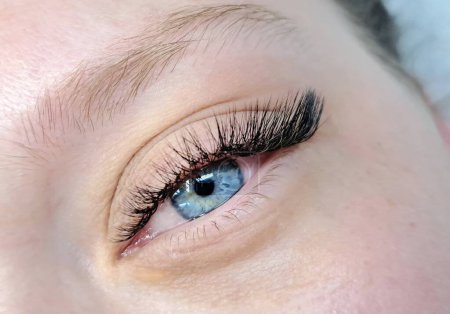 Nahaufnahme des Auges mit Wimpernverlängerungen, Schönheitssalon-Behandlung. Hochwertiges Foto