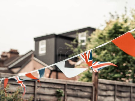Téléchargez les photos : Drapeaux de Grande-Bretagne agitant le vent dans le jardin de la maison anglaise, célébration du couronnement . - en image libre de droit
