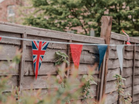 Foto de Banderas de Gran Bretaña ondeando en el viento en el jardín de la casa Inglés, celebración de la coronación . - Imagen libre de derechos