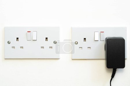 close up of english socket in the wall, electricity bills