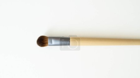 Wooden organic makeup brushes on white backdrop. Eco-friendly, sustainable beauty tools.