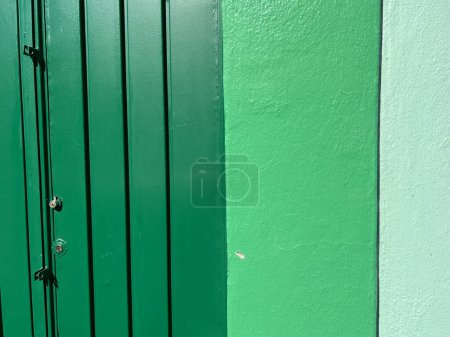 Téléchargez les photos : Plan rapproché d'une porte en métal vert et du mur d'un bâtiment - en image libre de droit