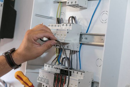 Foto de Instalación del disyuntor. Un técnico conecta los cables al disyuntor. Conexión de la central solar a la red eléctrica de la casa. - Imagen libre de derechos