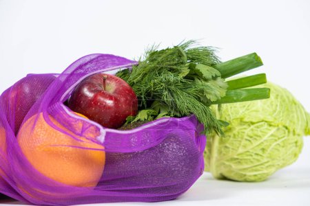 Téléchargez les photos : Maille en tissu pour fruits et légumes sur fond blanc. Une alternative réutilisable aux sacs en plastique - en image libre de droit