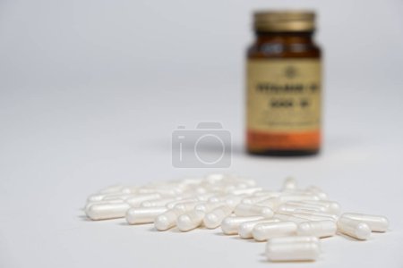 Téléchargez les photos : Capsules blanches de médicaments ou de vitamines sur fond blanc, espace pour le texte. - en image libre de droit