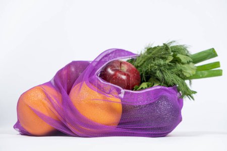 Téléchargez les photos : Maille en tissu pour fruits et légumes sur fond blanc. Une alternative réutilisable aux sacs en plastique - en image libre de droit