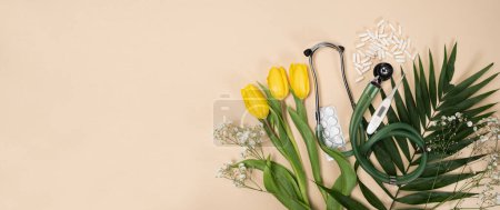 Bouquet of flowers and stethoscope on a beige background, a place for text, happy doctors day, nurses week and other medical holidays