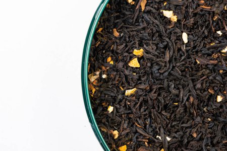 Foto de Black tea with orange peel and cinnamon close-up top view. - Imagen libre de derechos