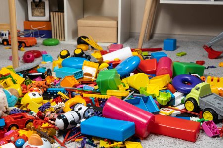 Foto de Una abundancia de juguetes en la habitación de los niños, una gran cantidad de piezas de plástico multicolor de diseñadores, piezas de repuesto para juguetes, figuritas y cubos - Imagen libre de derechos