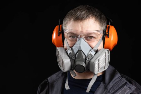 Foto de Retrato de un hombre con un respirador y auriculares protectores que cancelan el ruido orejeras. - Imagen libre de derechos