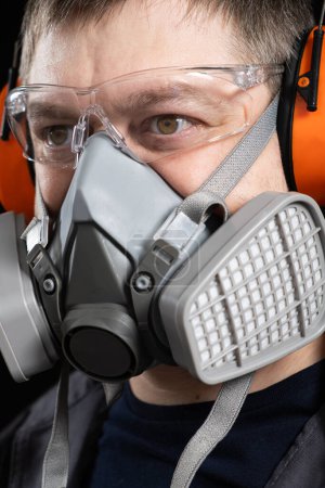 Téléchargez les photos : Portrait d'un homme portant un respirateur et un casque protecteur anti-bruit. - en image libre de droit