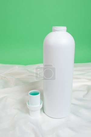 Natural liquid laundry detergent on a background of white satin fabric
