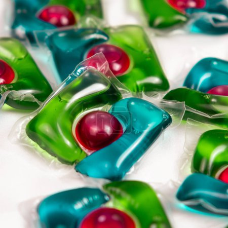 Lots of laundry pods on satin fabric close-up