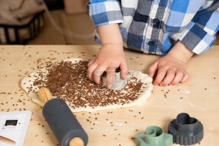 Childs manos haciendo galletas de masa usando moldes de masa, manos de cerca.