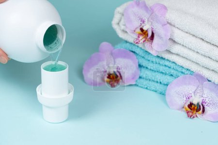 El proceso de verter el detergente líquido ecológico natural de la ropa del gel de la botella en la tapa.