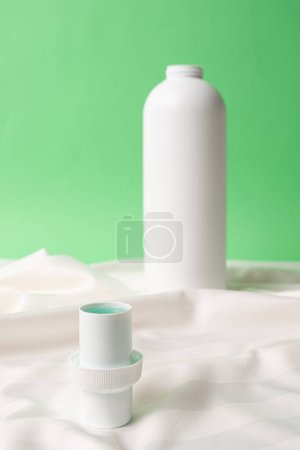 Natural liquid laundry detergent on a background of white satin fabric