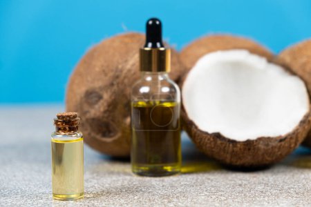 Photo for Coconut oil in a small glass bottle for skin and hair care - Royalty Free Image